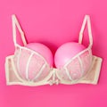 Bra with pink balloons on a pink background. Fun, conceptual photo, great big breasts. Complementary colors Royalty Free Stock Photo
