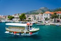 Brac, Croatia - May 17, 2016: Colourful Taxi boat in water of Marina Bol port of Pain in front of olt town Royalty Free Stock Photo