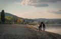 Girl and black stallion walking along the shores of Lake Bracciano in Lazio, Italy