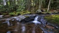 Autumn landscape - rocks covered with moss, fallen leaves. Mountain river with a waterfall Royalty Free Stock Photo