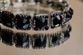 Bracelet with black stones on a glass table Royalty Free Stock Photo