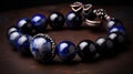 a bracelet with a blue and black bead and a silver clasp on a brown surface with a black and white bead around it Royalty Free Stock Photo