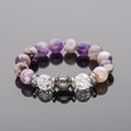 Bracelet made of amethyst and quartz,. Bracelet made of natural stones on the hand on a dark background with reflection Royalty Free Stock Photo