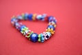 A bracelet made of beads on a red background Royalty Free Stock Photo