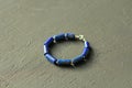 Bracelet made of natural stones. Blue stone lapis lazuli. Handmade jewelry. Handmade bracelets on a black modern background Royalty Free Stock Photo