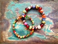 Bracelets with colorful beads on the old wooden table Royalty Free Stock Photo