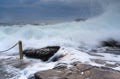 Bracing as powerful waves come crashing over rocks