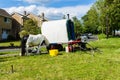 Bradford on Avon Wiltshire May 22nd 2019 An Irish cob/gypsy vanner grazing next to a plain vardo caravan Royalty Free Stock Photo