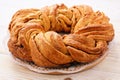 Braided cinnamon roll cake on wooden background.