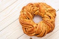 Braided cinnamon roll cake on wooden background.
