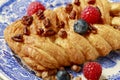 Braided danish bun made of puff pastry decorated with fresh fruits