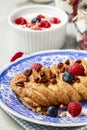 Braided danish bun made of puff pastry decorated with fresh fruits