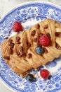 Braided danish bun made of puff pastry decorated with fresh fruits