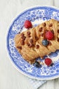 Braided danish bun made of puff pastry decorated with fresh fruits