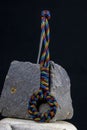 Braided paracord keychain on a background of stones.