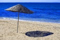 Braided straw umbrella on sandy beach