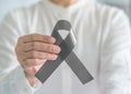 Brain cancer awareness with grey ribbon on person helping hand, symbolic bow color for Brain tumor, Allergies, Alpha-1 Antitrypsin