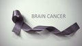 Brain cancer inscription, gray ribbon lying on table, awareness campaign, ad Royalty Free Stock Photo