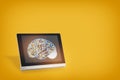 Brain on computer digital tablet on yellow background