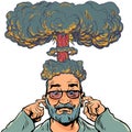Brain explosion. A strong load on the thoughts of a person. A man with a beard and glasses plugs his ears while he has