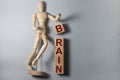 BRAIN message word on a wooden cube blocks with wooden person. mental health concept