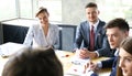 Brainstorm. Group of business people looking at the laptop together. One business woman looking at camera.