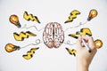 Brainstorming creative idea concept with man hand drawing colorful sketch of human brain parts, yellow lightning strike symbols Royalty Free Stock Photo