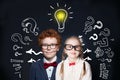 Brainstorming and idea concept. Smart successful children girl and boy student with lightbulb on blackboard background Royalty Free Stock Photo