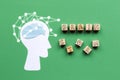 Brainstorming. A paper silhouette of a man's head thinking about a new idea. Wooden cubes on a green background. Flat Royalty Free Stock Photo