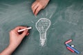 Brainstorming, Start-Up and Marketing Plan concept. Woman& x27;s and a child& x27;s hand draws on a chalkboard light bulb Royalty Free Stock Photo