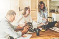 Brainstorming, teamwork, startup. Man is using laptop, girls looking on screen of laptop, discussing business plan. Royalty Free Stock Photo