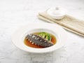 Braised Japanese Sea Cucumber in Oyster Sauce served in a dish side view on grey background