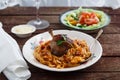 Braised Rabbit Leg in Tomato Sauce with Homemade pasta, dark rustic background Royalty Free Stock Photo