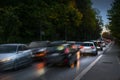 Braking cars at rush hour jam in a dark narrow street to town with wet asphalt on the way to business work early in the morning, Royalty Free Stock Photo