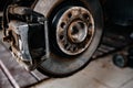 Braking system car, with brake disc and brake pad. Repairing suspension of automobile at garage. Royalty Free Stock Photo