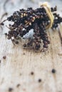 Branch of black pepper dry on wood table. Royalty Free Stock Photo