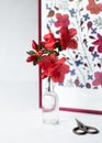 A branch of a blooming azalea in a glass vase against the background of a botanical picture, a herbarium of dried azalea