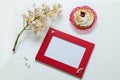 Branch of the blossoming chestnut, red frame for a congratulation inscription, lemon cake on a white background.