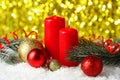 Branch of Christmas tree with balls and candles on snow, close up Royalty Free Stock Photo