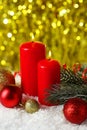 Branch of Christmas tree with balls and candles on snow, close up Royalty Free Stock Photo