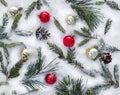 Branch christmas tree, christmas balls and cones spruce on snow. Top view, flat lay Royalty Free Stock Photo