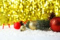 Branch of Christmas tree with balls on snow, close up Royalty Free Stock Photo