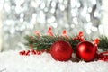 Branch of Christmas tree with balls on snow, close up Royalty Free Stock Photo