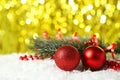 Branch of Christmas tree with balls on snow, close up Royalty Free Stock Photo