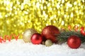 Branch of Christmas tree with balls on snow, close up Royalty Free Stock Photo