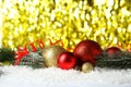 Branch of Christmas tree with balls on snow, close up Royalty Free Stock Photo