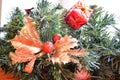 A branch of a green New Year tree decorated with red, small gifts, toys, golden leaves and ball Royalty Free Stock Photo