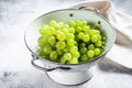 A branch of green ripe grapes in a colander. White background. Top view Royalty Free Stock Photo
