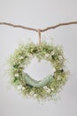 On the branch hangs a ring cradle for a photo shoot of newborns, a dream catcher, a floral arrangement with eustomas