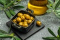 Branch with olives and a bottle of olive oil on dark background. top view. place for text Royalty Free Stock Photo